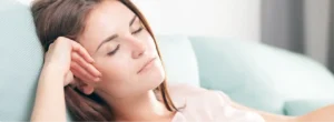Woman resting comfortably on a couch.