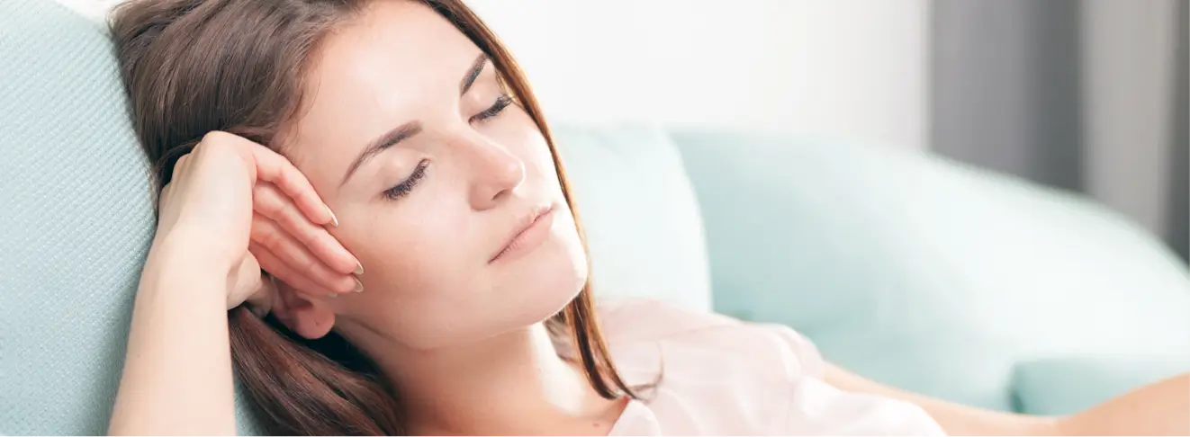 Woman resting comfortably on a couch.