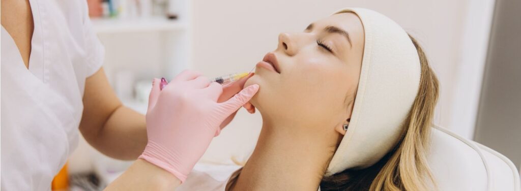 Person receiving lip filler injection in a clinical setting