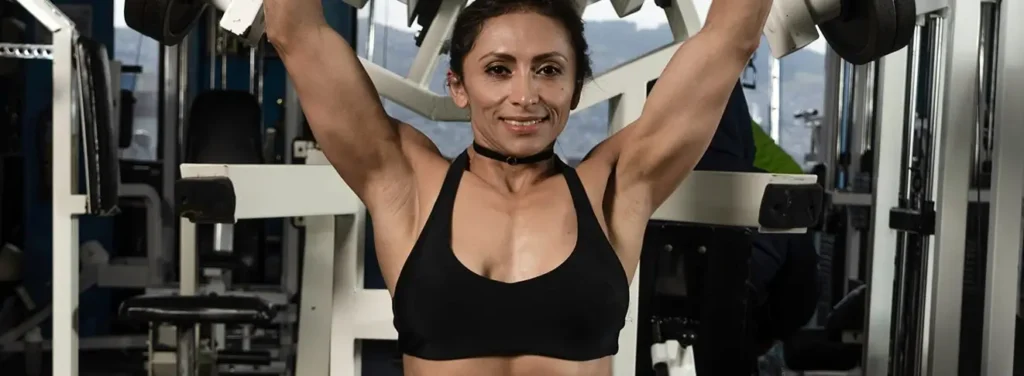 Athletic woman doing a chest workout at the gym, relevant to implant placement lifestyle considerations